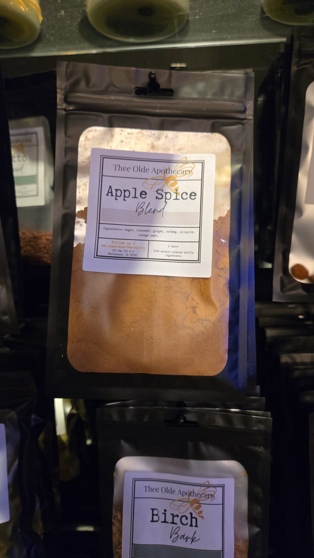Packaged product labeled 'Apple Spice' and 'Birch Bark' on a shelf.