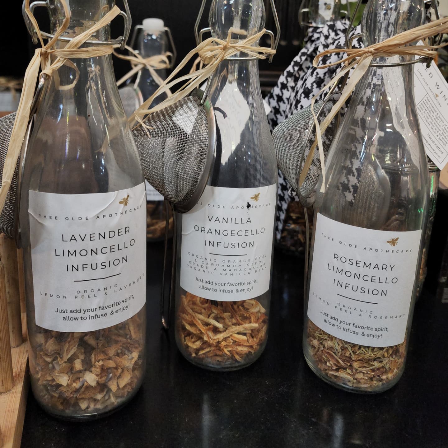 Two clear glass decanters with a silver strainer and a bundle of lavender, tied with a string and labeled 'Limoncello'.